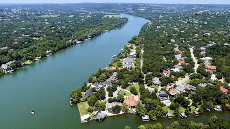 Aerial view of Hudson Bend neighborhood along Lake Austin, surrounded by lush greenery and waterfront homes.