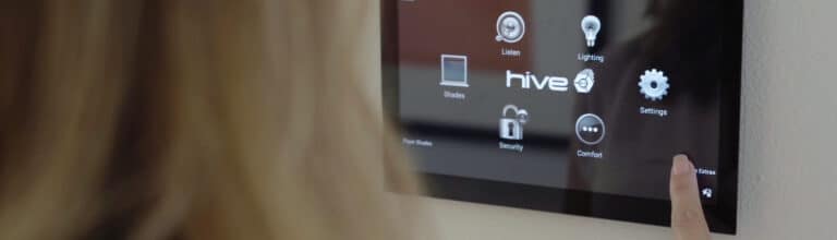 Close-up of a woman using a smart home control panel with Hive automation options for lighting, security, and comfort.