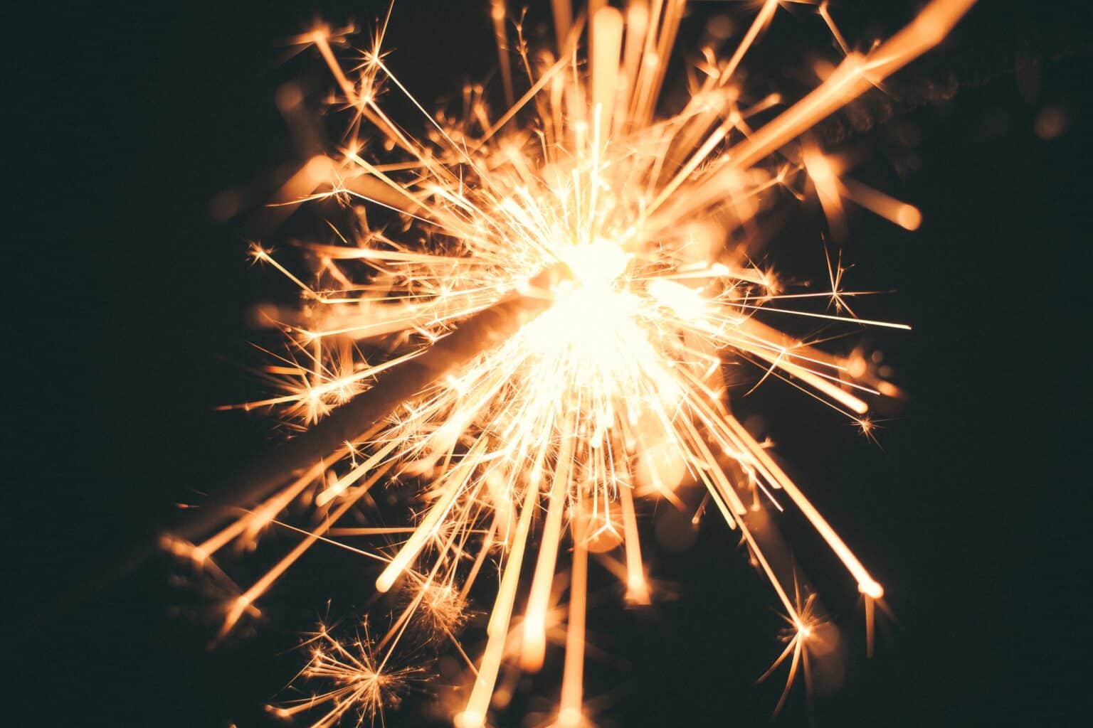 Close-up of a glowing sparkler against a dark background, symbolizing new beginnings with smart home systems in the New Year.