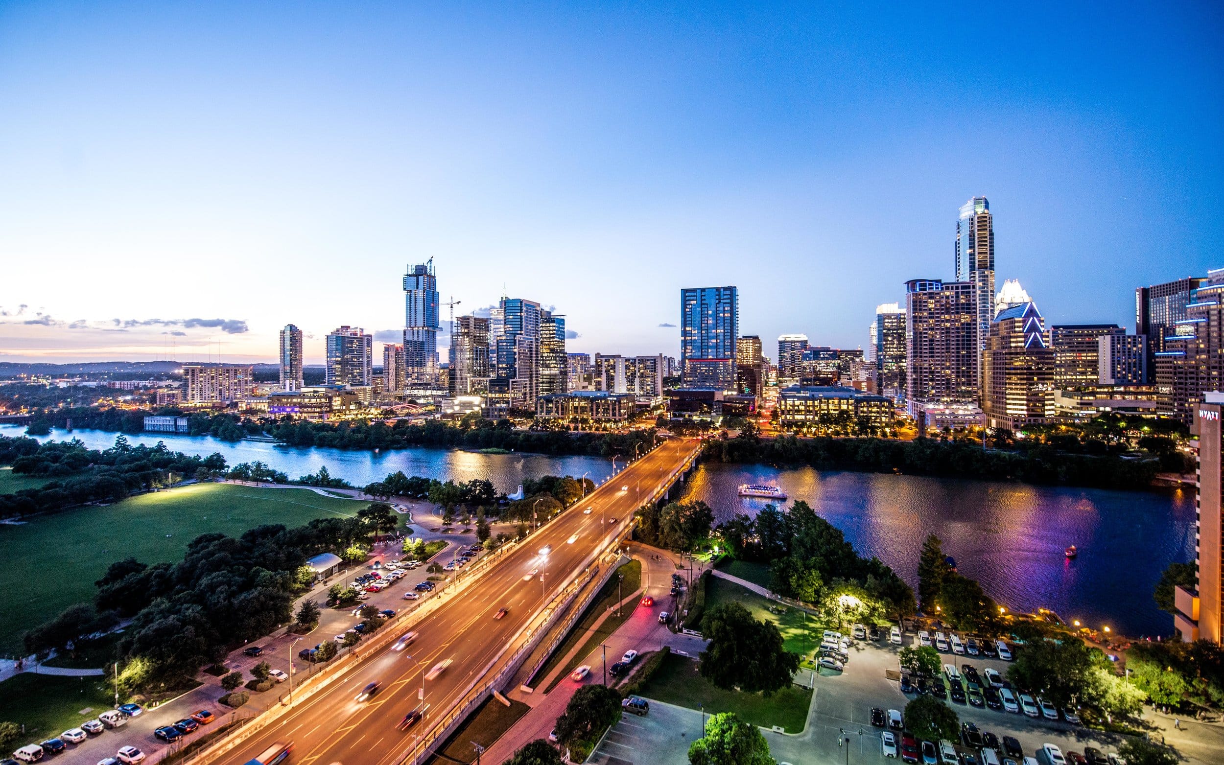 Downtown Austin skyline at dusk with city lights reflecting on the river, representing the rise of luxury smart homes in the area.