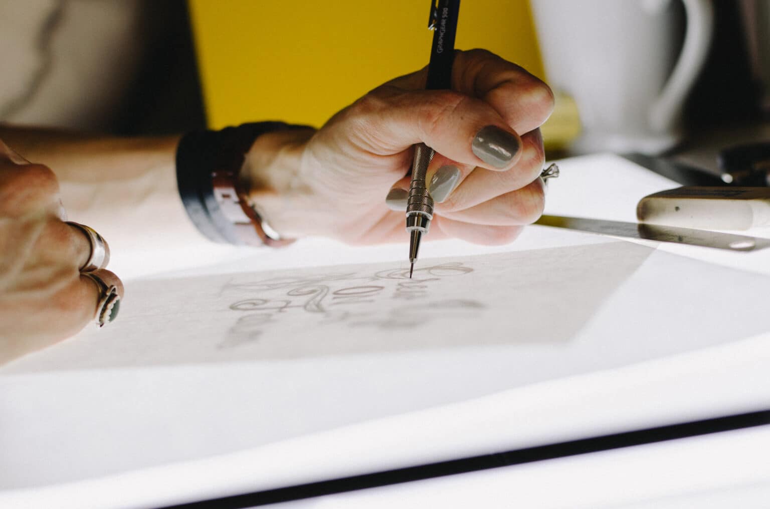 Close-up of an interior designer sketching on paper, symbolizing collaboration in custom lighting design Austin Texas.
