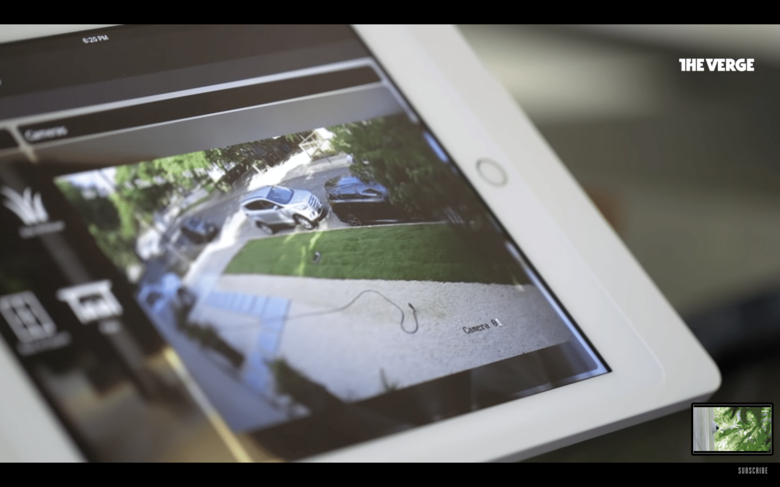 Tablet showing a live feed of a driveway and parked cars, connected through smart home security systems.