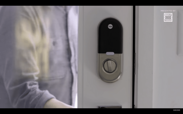 Smart lock installed on a front door, integrated with a modern alarm system for home security.