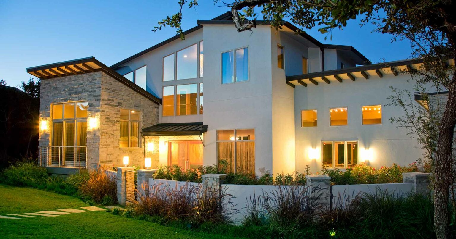 Rustic-inspired modern house illuminated at dusk, representing the comfort and innovation of smart homes.