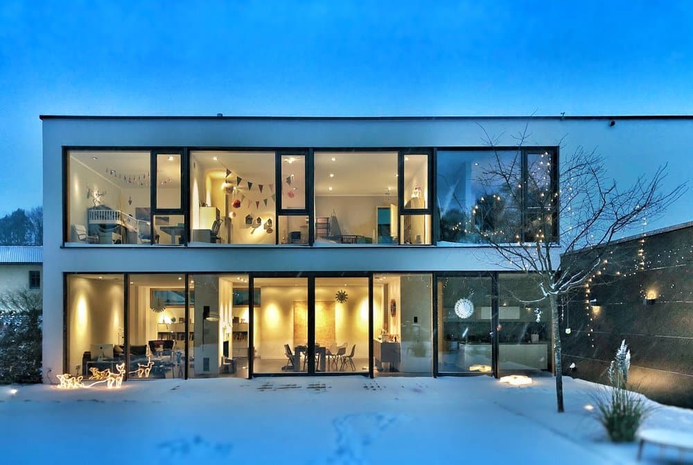 Modern two-story home illuminated at dusk, showcasing the role of smart home security in protecting luxury living spaces.