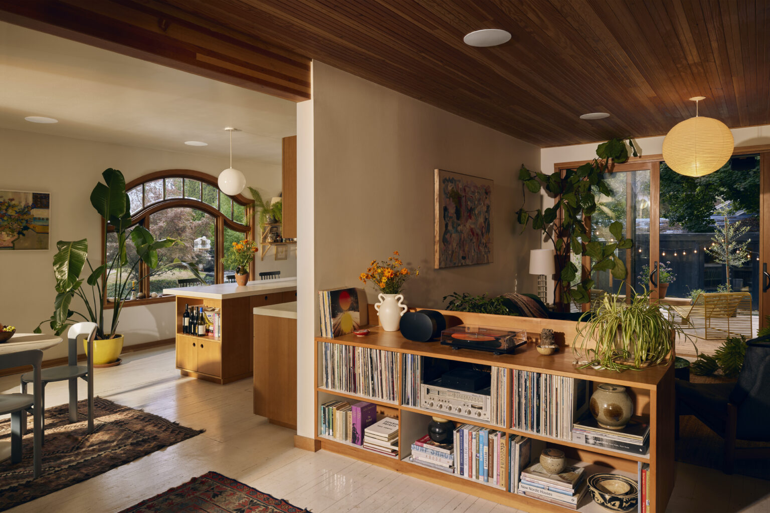 Bright and organized living space with plants and shelving, symbolizing how smart home devices can support next-level spring cleaning.